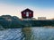 Red boat house at pier, rocky island, Norway. Traditional red white building at pier close to sea