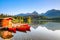 Red boats moored at wooden house on a lake.