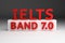 Red bold IELTS BAND 7.0 SEVEN on white pedestal