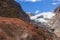 Red boulder on a background of a glacier. View of Franz Joseph Glacier in New Zealand