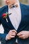 Red boutonniere in the grooms jacket close up