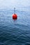 Red bouy on a calm lake isolated on blue background