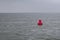 Red bouy floating in sea