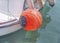 Red bouy tied at white fishing boat tied on marine dock