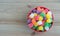 Red bowl filled with colorful gumdrops on a wood background