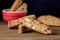 Red Bowl with Fresh Baked Biscotti Cantucci Italian Almond Sweets Biscuits Cookies Wooden Background Copy Space