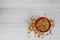 A red bowl on full of granola on white wood table, top view