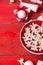 Red bowl with white flowers in water, bottle with lotion on wooden table , spa background