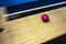 Red bowling ball with great speed is rolling down the track, on a blurred background. Shooting in motion