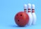 Red Bowling Ball and white skittles isolated on blue background