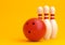 Red Bowling Ball and white skittles isolated on yellow background