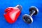 Red boxing glove and old dumbbells on blue exercise mat