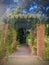 A red brick arch full of climbing plants in the garden.