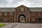 Red brick barracks with a arch gate and clock in historical Fort George complex in Scotland