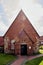 Red brick church with small porch in a village in Lower Saxony, Germany. Backlight shot with sun rays and light reflections