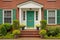 red brick colonial house with a green central front door