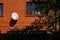 Red brick house with decorative window grates and white satellite dish