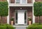 Red brick house exterior facade with front door and front yard