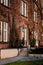 Red brick house with a porch entwined with dry vines