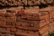 Red brick packed in stack are stored on ground outdoors at a hardware store warehouse. Building bricks on pallet on an