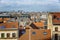 Red brick roofs of an old European city against a bright blue cloudy sky