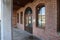 A red brick store front with concrete pillars and arches and arched windows with brown wooden trim in Douglasville