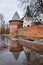 The red brick tower reflected in a puddle of melt in the spring