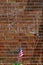 Red brick wall chalk inscription Be Kind and flag of the USA