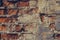 Red brick wall in the cracks. Shattered brick wall close up. Old ruined brick wall. Dilapidated brick wall. Urban texture.   Grung