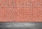 Red brick wall and gray asphalt floor