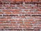 Red brick wall with grey mold. Three horizontal lines of black r