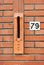 Red brick wall with mailslot and number