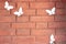 red brick wall with pasted paper butterflies