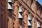 Red brick wall with row of narrow windows and metal wall vents