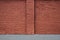 Red brick wall with the strip of asphalt and vertical column.