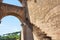 Red brick walls of colosseum and archway showing the brick mason