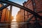 The red brick warehouse - Speicherstadt district in Hamburg Germany, framed by steel bridge arch beams with canal