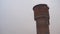 Red brick water tower in winter season. Old high tower in countryside in gloomy weather.