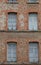 Red bricks and old peeling windows of an old industrial building