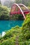 Red bridge over river in forest