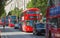 Red British double decker buses and taxis in Oxford street, the main destination for shopping in West End London. Modern life and