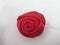 red brooch craft in the shape of a rose made of satin