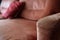 Red and brown armrest of a sofa with pillow
