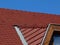 Red brown clay roof ridge tiles and flat sloped tiles. blue sky