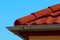 red brown color sandy textured modern concrete roof tile closeup detail. half round ridge tiles