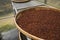 Red or brown peppercorns drying in drying room or box on plates of reed on black pepper plantation. Drying of red