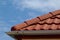 Red brown sandy textured modern concrete roof tile closeup detail. half round ridge tiles