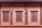 Red-brown wooden windows and classic red cement wall