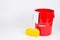 Red bucket with wash cloth and sponge on white background