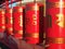 Red Buddhist prayer wheels with Golden text of prayers in Sanskrit illuminated by sunlight